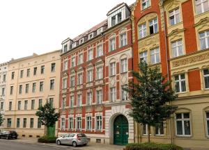 un grand bâtiment avec des voitures garées devant lui dans l'établissement Petit Martha - gemütlich eingerichtete Wohnung, à Görlitz