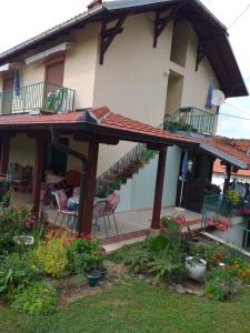 Casa con terraza y patio con flores en Vila Dalmatinka en Gornja Toplica