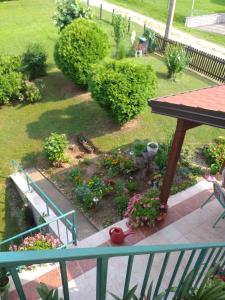 a garden with flowers and a table on a balcony at Vila Dalmatinka in Gornja Toplica
