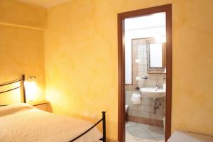 1 dormitorio con 1 cama y baño con lavamanos en S'Alzolitta, en Magomadas