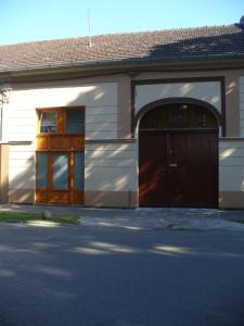 a building with a garage with a brown door at Berta Apartman in Senta