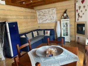 a living room with a blue couch and a table at Mountain Living Apartment Asiago in Lusiana