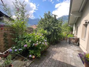 d'une terrasse avec des fleurs, une table et une clôture. dans l'établissement Ferienwohnung LISL, à Obervellach