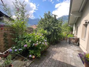 上韋拉赫的住宿－Ferienwohnung LISL，一个带鲜花和桌子的庭院和围栏
