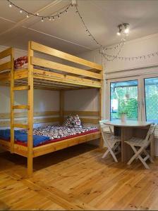 a room with a bunk bed and a table and a desk at Domek letniskowy Pogorzelica in Pogorzelica