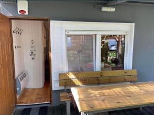 un banco de madera sentado frente a una ventana en Domek letniskowy Pogorzelica, en Pogorzelica