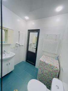 a bathroom with a toilet and a sink and a mirror at Maria House in Kutaisi