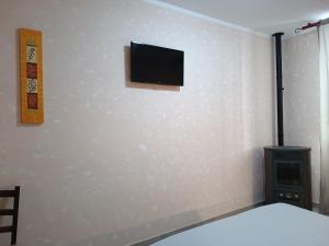 a bedroom with a flat screen tv on a wall at La Mezzanella Guesthouse in Porto Torres