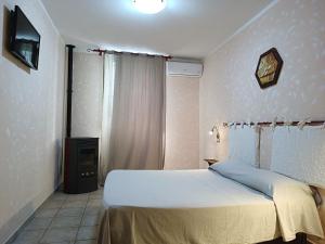 een slaapkamer met een bed en een televisie. bij La Mezzanella Guesthouse in Porto Torres
