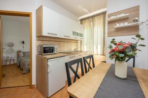 eine Küche und ein Esszimmer mit einem Tisch und einer Mikrowelle in der Unterkunft Apartments Claudia in Crikvenica