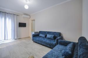 a living room with a couch and a tv at Luka Apartments in Sarandë