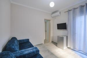 a living room with a blue couch and a television at Luka Apartments in Sarandë +53 photos