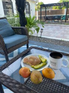 a tray with a plate of food and a cup of coffee at Indianna Guesthouse in Treasure Beach