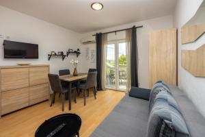 ein Wohnzimmer mit einem Sofa und einem Tisch mit Stühlen in der Unterkunft Apartments Claudia in Crikvenica