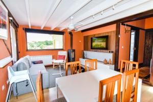 a living room with orange walls and a table and chairs at Precioso apartamento con jardín y piscina in Oruña