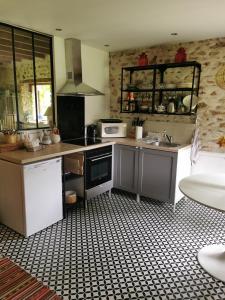 a kitchen with a sink and a stove top oven at Domaine de la Folicoeur in Sainte-Colombe-près-Vernon