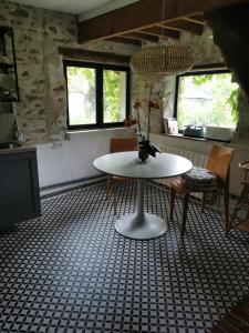 ein Raum mit einem Tisch und Stühlen in einem Raum in der Unterkunft Domaine de la Folicoeur in Sainte-Colombe-près-Vernon + 5 Fotos