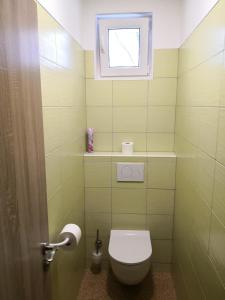 a small bathroom with a toilet and a window at Penzion Zelená zahrada in Kladenské Rovné