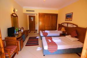 a hotel room with two beds and a television at Sharm al-Sheikh, Egypt - Hotel Apartment in Sharm El Sheikh