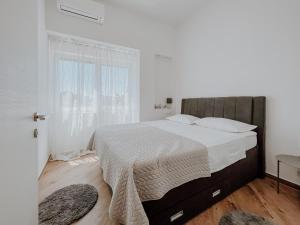 una camera da letto bianca con un letto grande e una finestra di Apartment Papedoni Pula a Pola (Pula)