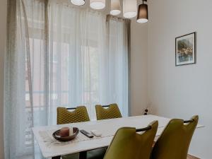 a dining room with a white table and chairs at Apartment Papedoni Pula in Pula