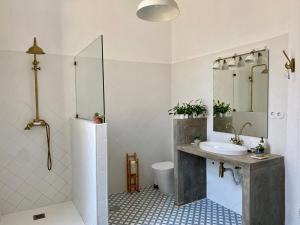 a bathroom with a sink and a toilet and a mirror at Casa dos Caminhos de Santiago in Mosteiró