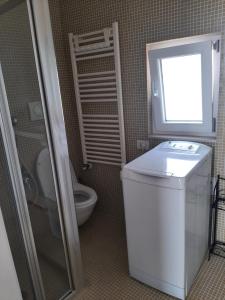 a small bathroom with a toilet and a window at loft giulia in Bari
