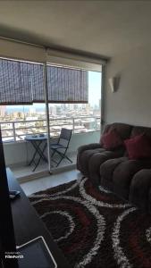 a living room with a couch and a large window at Iquique, ED. MATIZ CAVANCHA in Iquique
