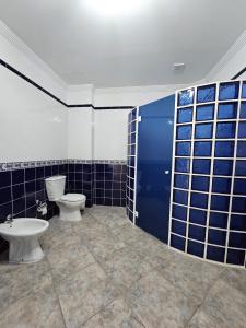 La salle de bains est pourvue de 2 toilettes et de murs carrelés bleus. dans l'établissement CRISOL APARTAMENTOS, à Tacoronte