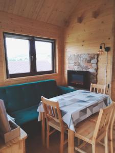 a room with a table and a couch and a fireplace at Pod Bercem in Solina