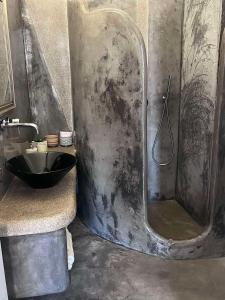 a bathroom with a shower with a black sink at suite diminutif in Adamas