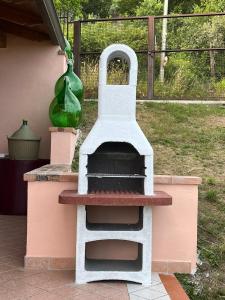 - un barbecue extérieur avec un vase vert au-dessus dans l'établissement Pink House, à Perdifumo