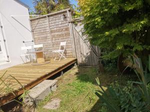 a wooden deck with a chair and a fence at Charmante maisonnette. in Brest