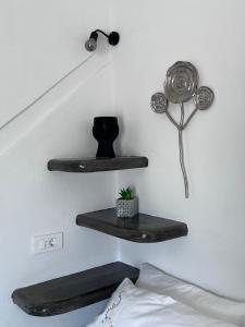 a bedroom with two black shelves on the wall at suite diminutif in Adamas