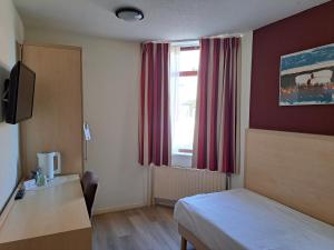 ein Hotelzimmer mit einem Bett und einem Fenster in der Unterkunft Hotel Restaurant Boven Groningen in Delfzijl