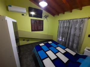 1 dormitorio con 1 cama y TV en la pared en Hospedate en nuestro hogar y disfruta unas lindas vacaciones en Termas de Rio Hondo en Termas de Río Hondo