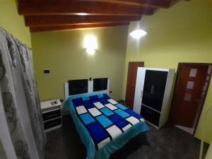 1 dormitorio con 1 cama con sábanas azules y blancas en Hospedate en nuestro hogar y disfruta unas lindas vacaciones en Termas de Rio Hondo en Termas de Río Hondo