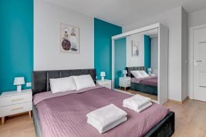 a bedroom with two beds and a mirror at Apartament Letnica Białe Piaski by TriApart in Gdańsk