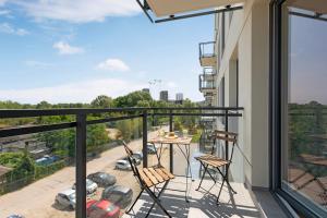 a balcony with a table and chairs and a view at Apartament Letnica Białe Piaski by TriApart in Gdańsk