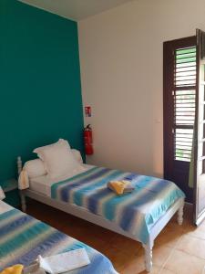 a bedroom with two beds and a green wall at RESIDENCE DE VACANCES MON REFUGE - BUNGALOW DE TYPE T3 in Grande Anse