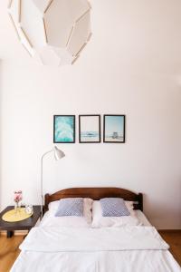 ブワディスワボボにあるApartamenty Baltyckieのベッドルーム1室(ベッド1台付)が備わります。壁に3枚の写真が飾られています。