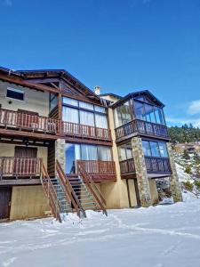 a large building with wooden stairs in the snow at Maison - Les Angles T4 70m2 - Vue exceptionnelle in Les Angles