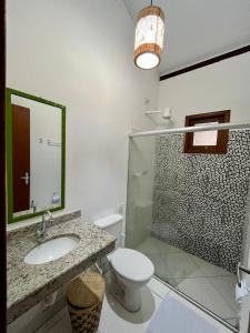 a bathroom with a sink and a toilet and a mirror at D'Ajuda Inn in Arraial d'Ajuda