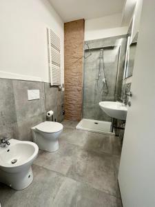 La salle de bains est pourvue de toilettes, d'un lavabo et d'une douche. dans l'établissement Lux apartments e, à Follonica