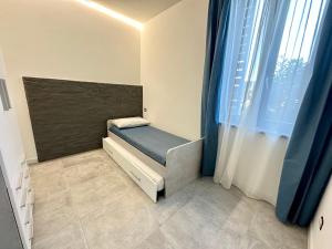 um pequeno quarto com uma cama e uma janela em Lux apartments e em Follonica
