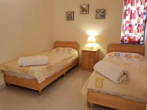 ein Schlafzimmer mit 2 Betten und einer Lampe auf einem Tisch in der Unterkunft Charming apartment-wifi-sleeps 5 in Marsaskala