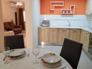 einen Esstisch mit 2 Stühlen und eine Küche in der Unterkunft Charming apartment-wifi-sleeps 5 in Marsaskala