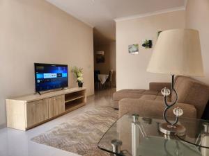 ein Wohnzimmer mit einem TV und einem Sofa in der Unterkunft Charming apartment-wifi-sleeps 5 in Marsaskala