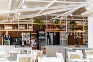 Pousada dos Sonhos في فلوريانوبوليس: مطعم به بار به طاولات وكراسي بيضاء
