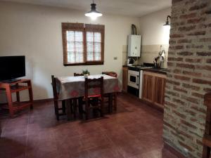 a kitchen with a table and chairs and a kitchen with a television at Armonía in Victoria